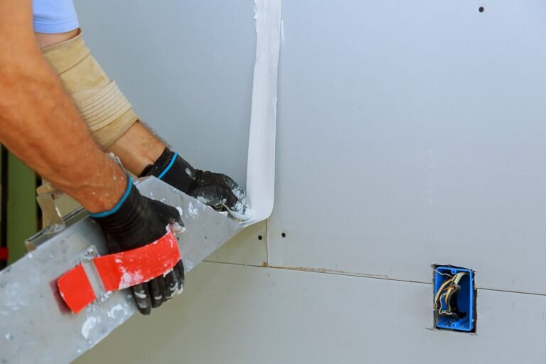 Worker installing gypsum board to wall